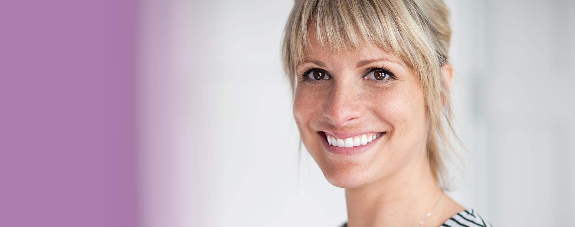 Junge Frau lacht nach einem Bleaching beim Zahnarzt in Frechen.